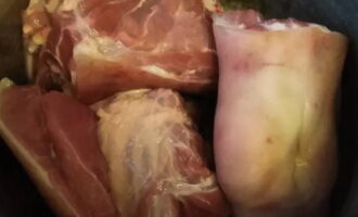 Рульку промойте и поместите в глубокую кастрюлю для варки блюда.